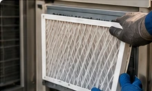 Gloved hands handling an HVAC air filter