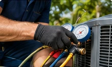 Technician checking refrigerant gauges on an outdoor unit